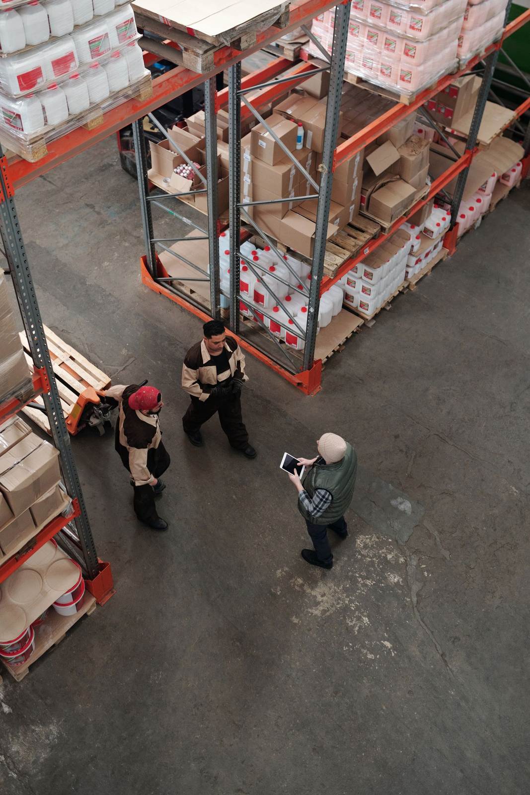 Workers discuss logistics in a busy warehouse setting, enhancing teamwork and efficiency